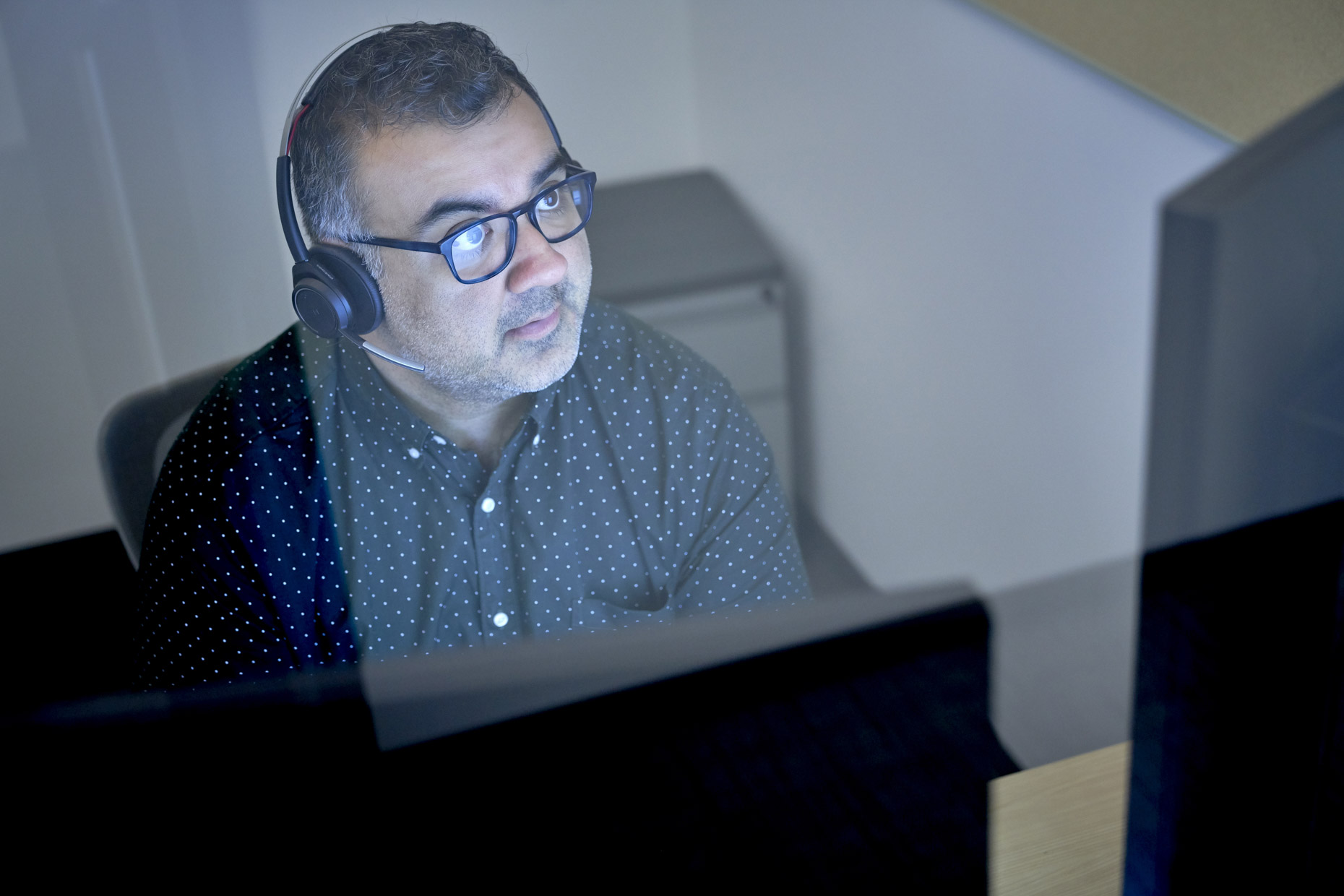 Man with headset working in office on computer