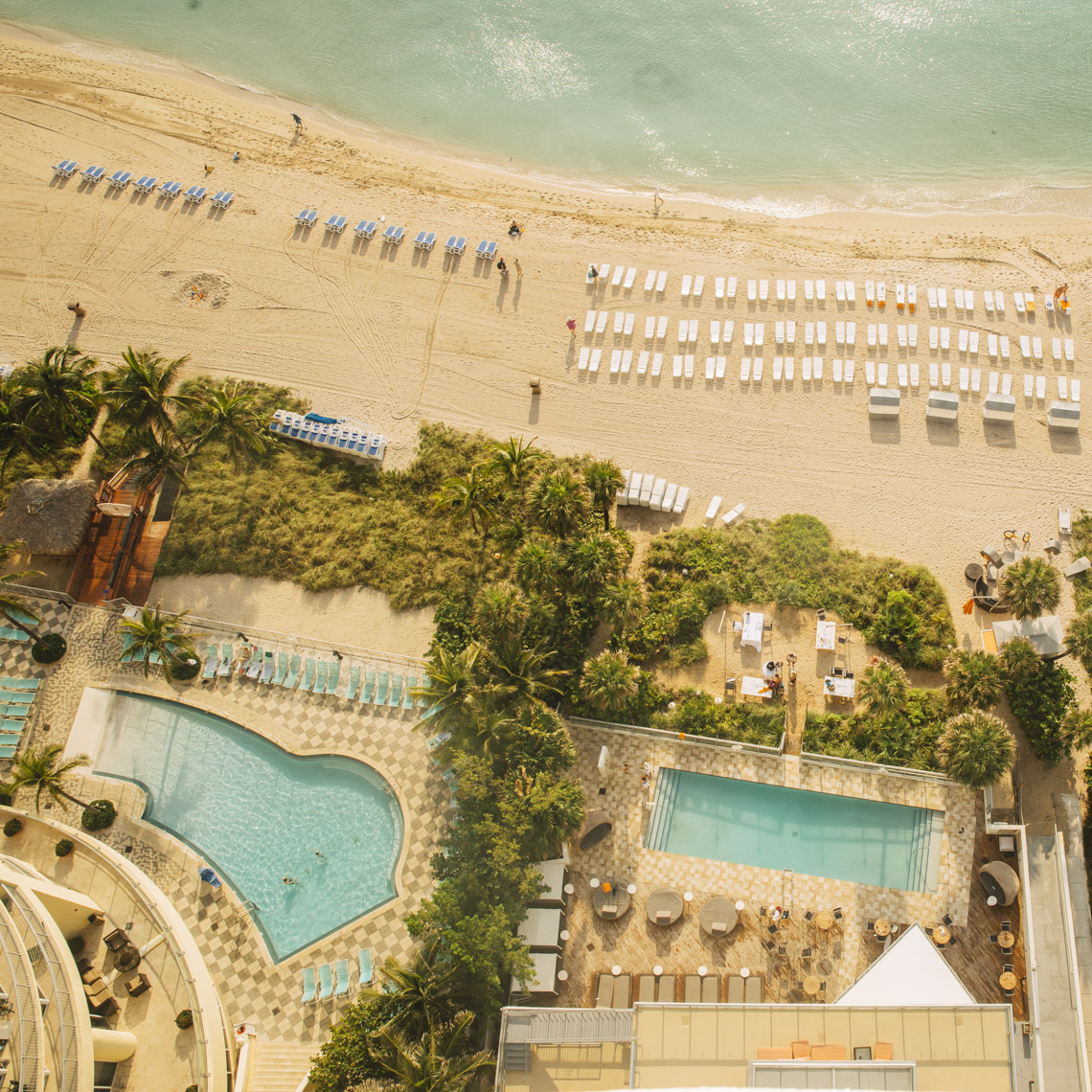 Overhead view of hotel resort pool by beach and ocean