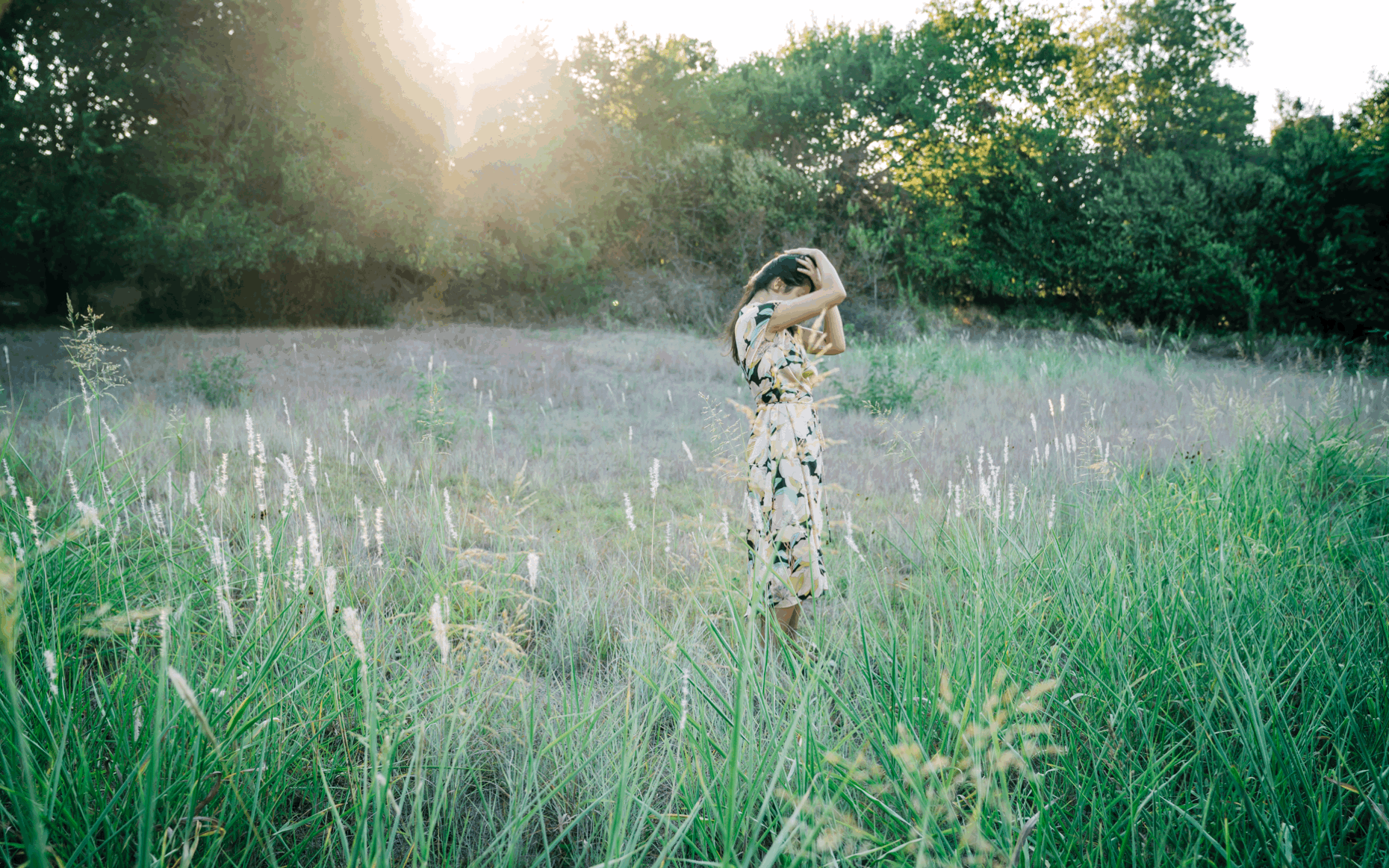 woman-in-floral-dress-dancing-in-grass-field