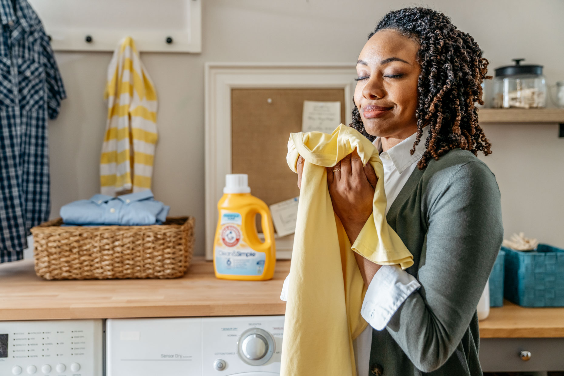 Woman smelling freshly washed shirt with arm and hammer laundry soap